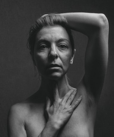 topless woman with left hand on head