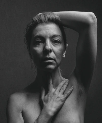 topless woman with left hand on head