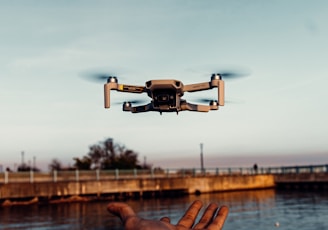 white drone flying over the sea during daytime