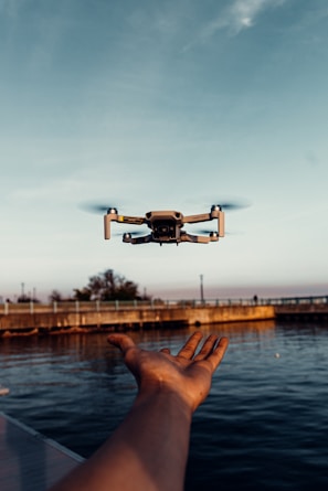 white drone flying over the sea during daytime