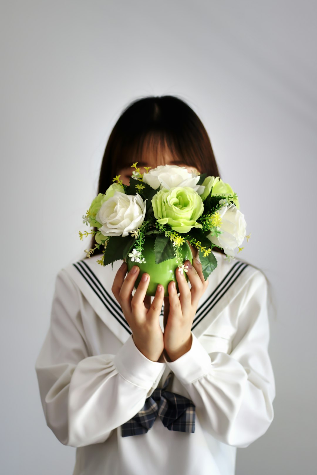 woman in white long sleeve shirt holding bouquet of white roses