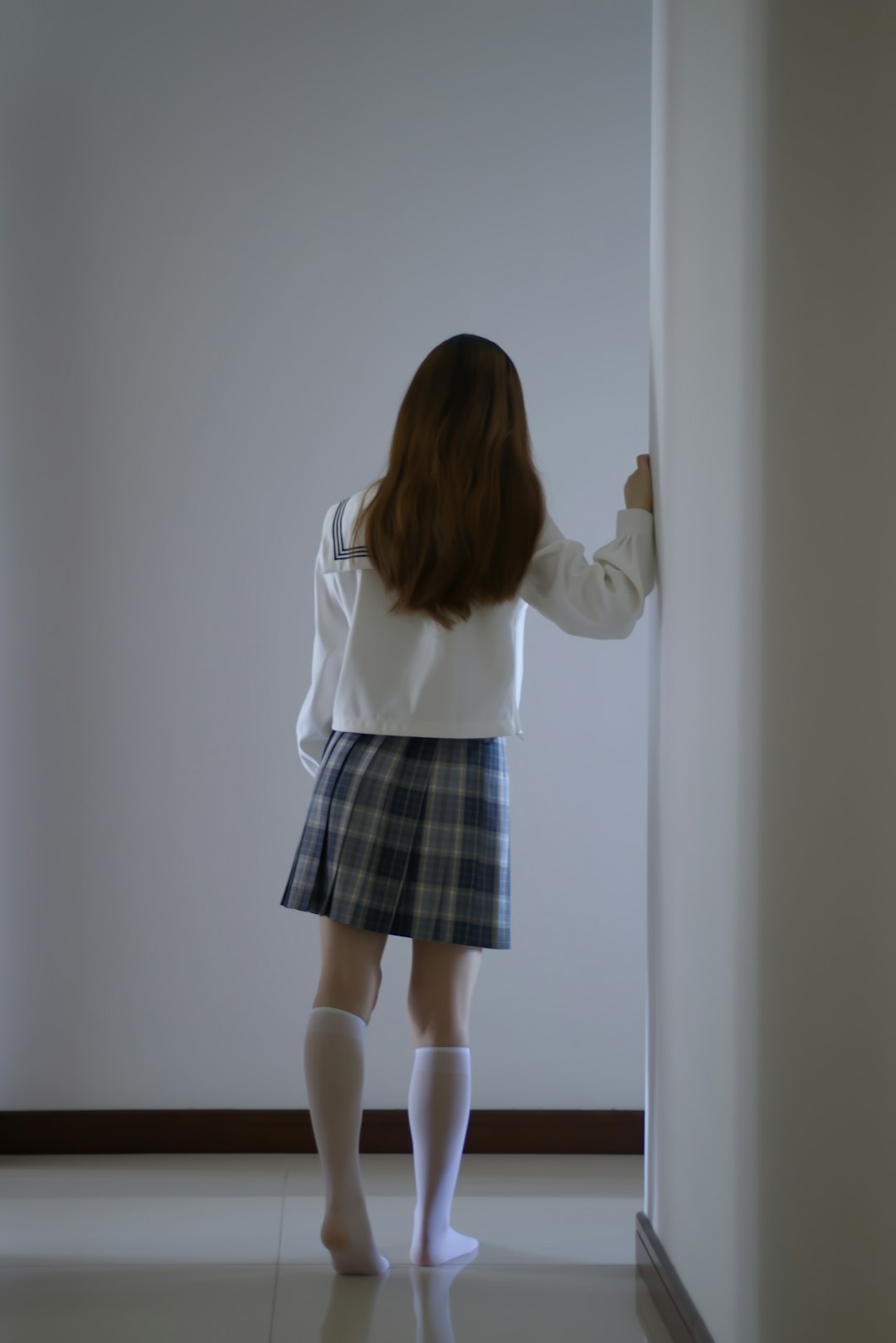 woman in white long sleeve shirt and black and gray plaid skirt