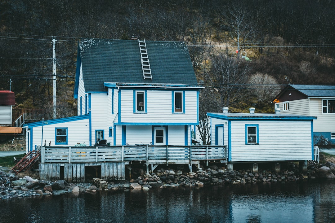 white and blue wooden house near body of water during daytime