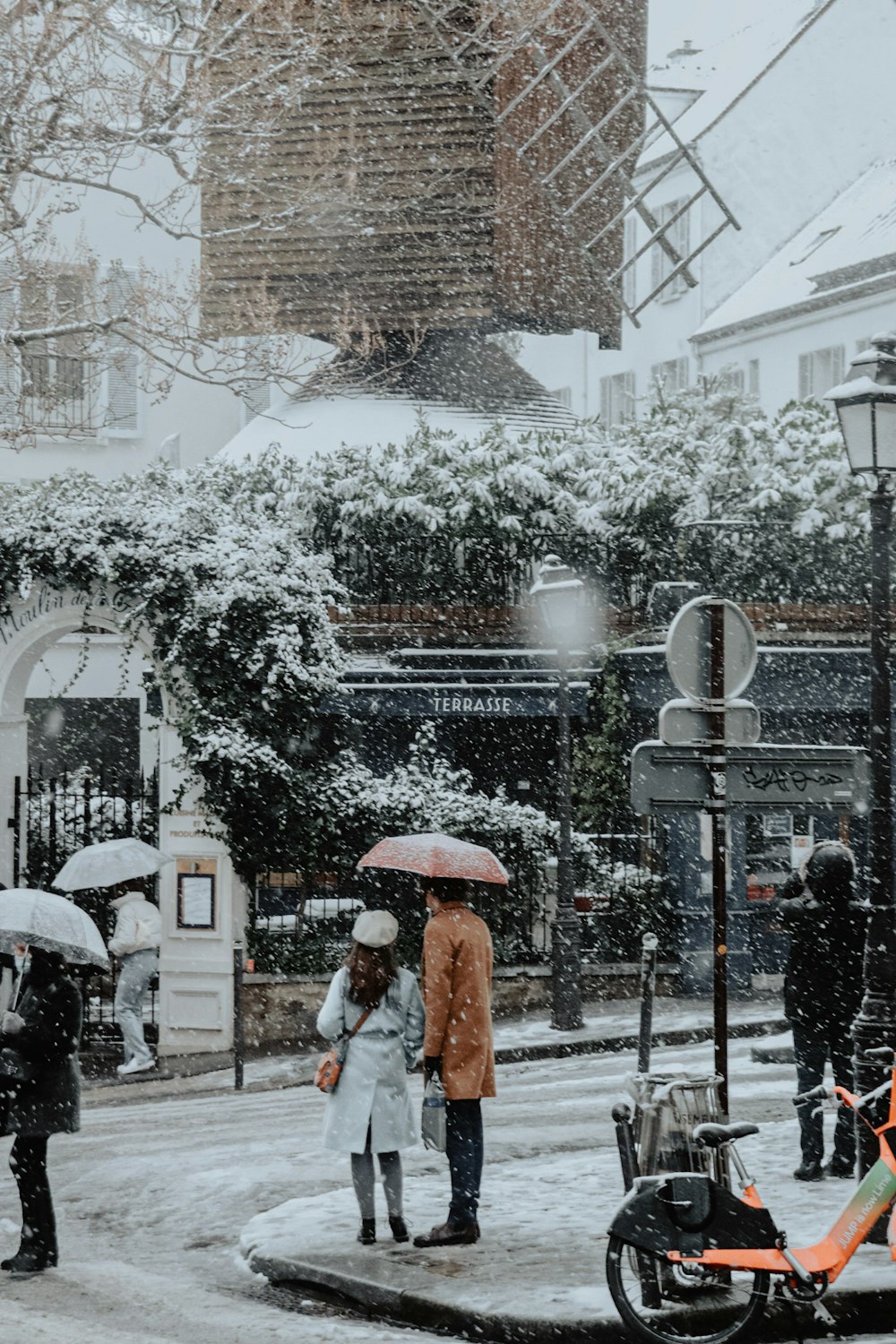 woman in white and brown dress holding umbrella walking on street during daytime