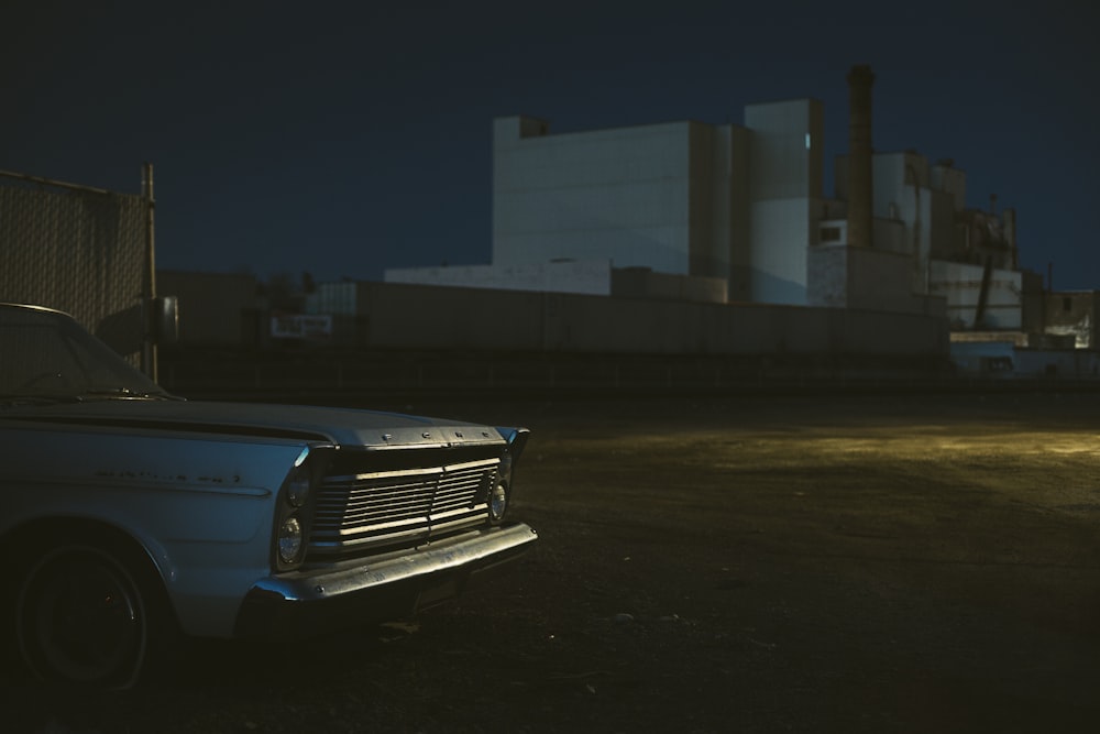 blue car parked near white building during night time