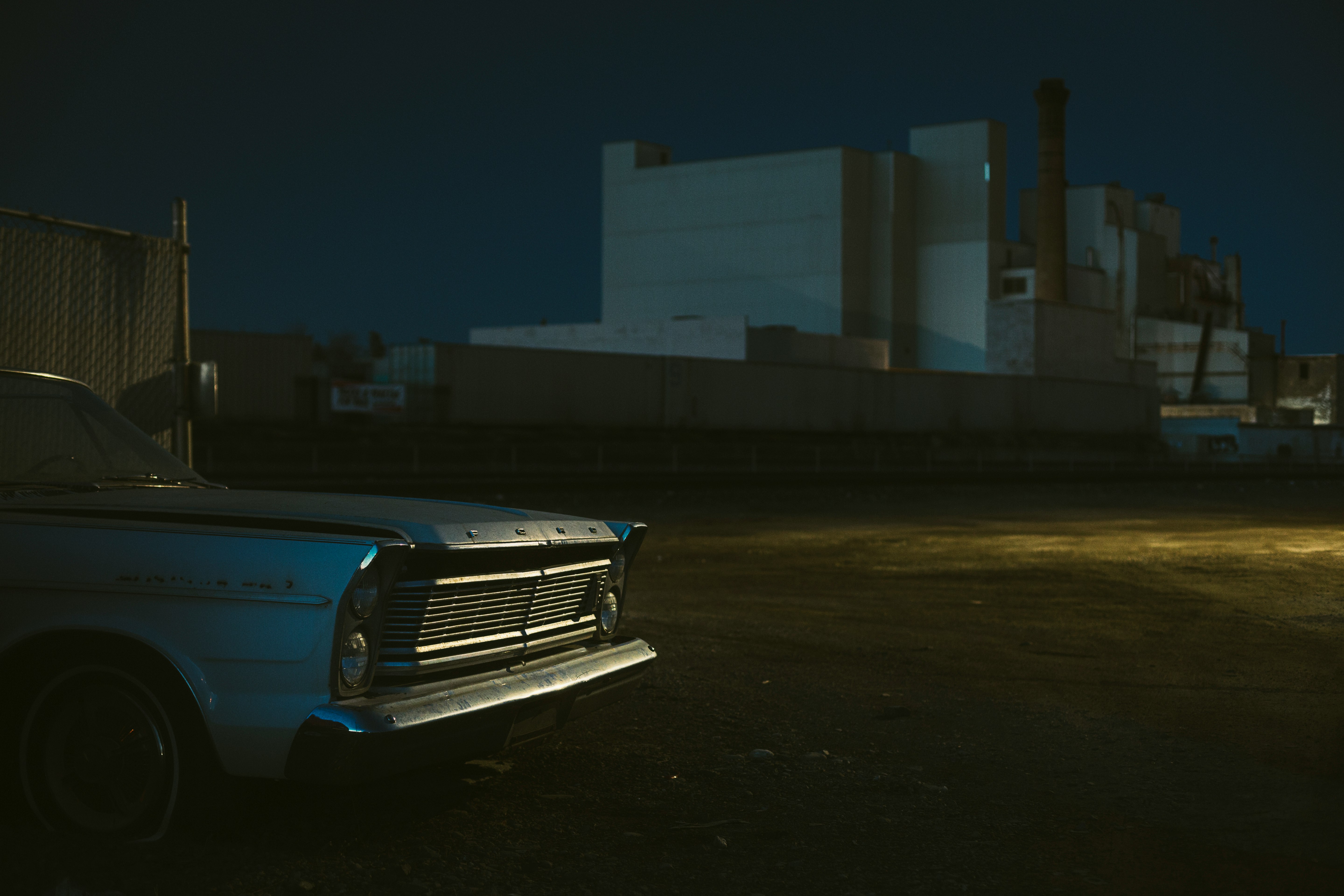 blue car parked near white building during night time