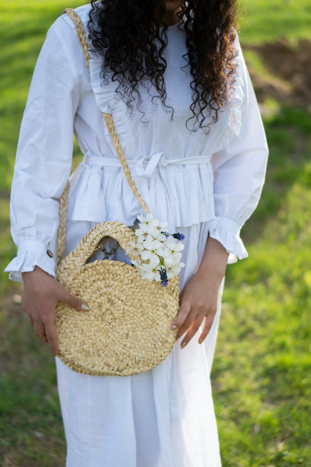 woman in white long sleeve shirt holding brown woven basket