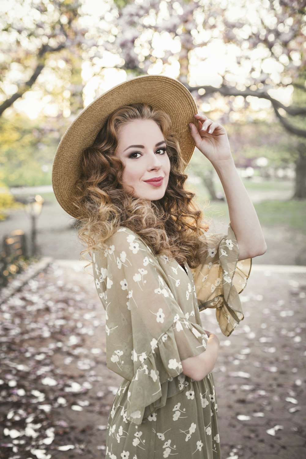 woman in brown floral dress wearing brown straw hat