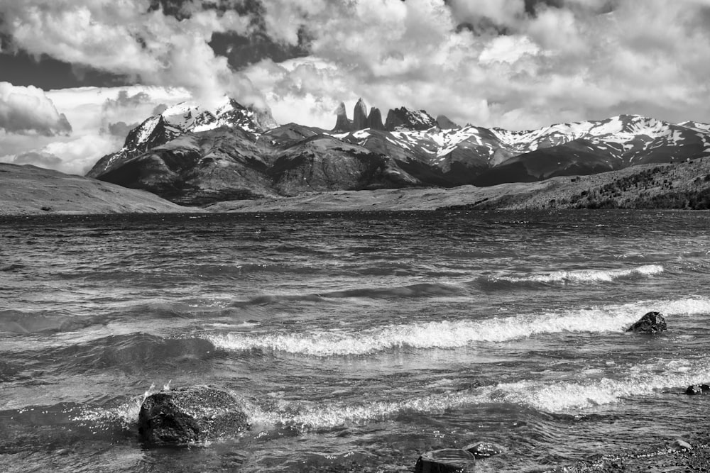 grayscale photo of sea waves crashing on rocks