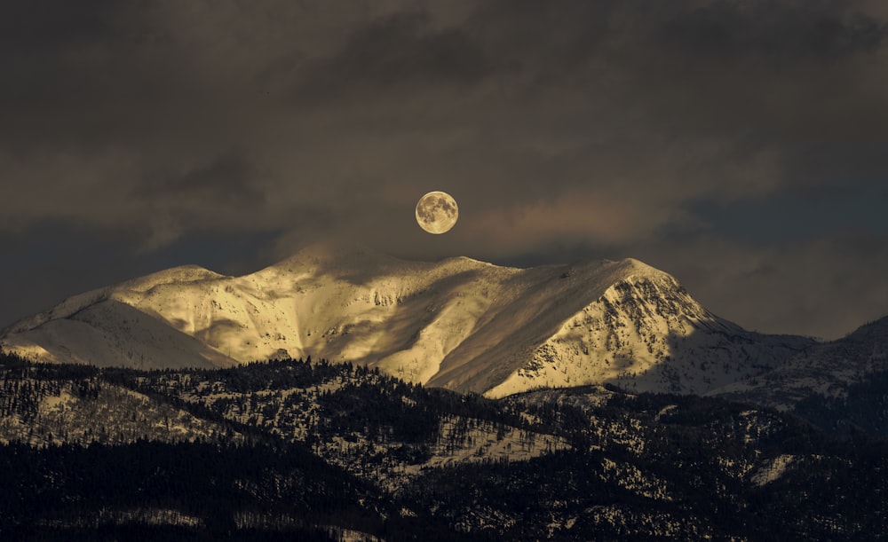 Montaña cubierta de nieve bajo la luna llena