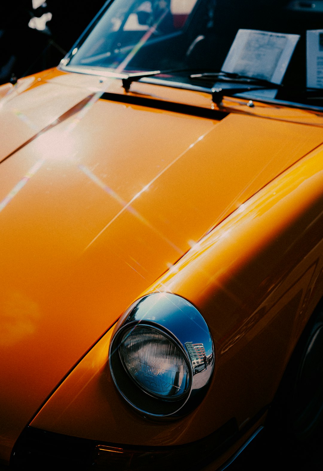 orange car with blue and silver emblem