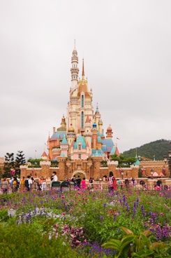 brown and green castle surrounded by green trees under white clouds during daytime