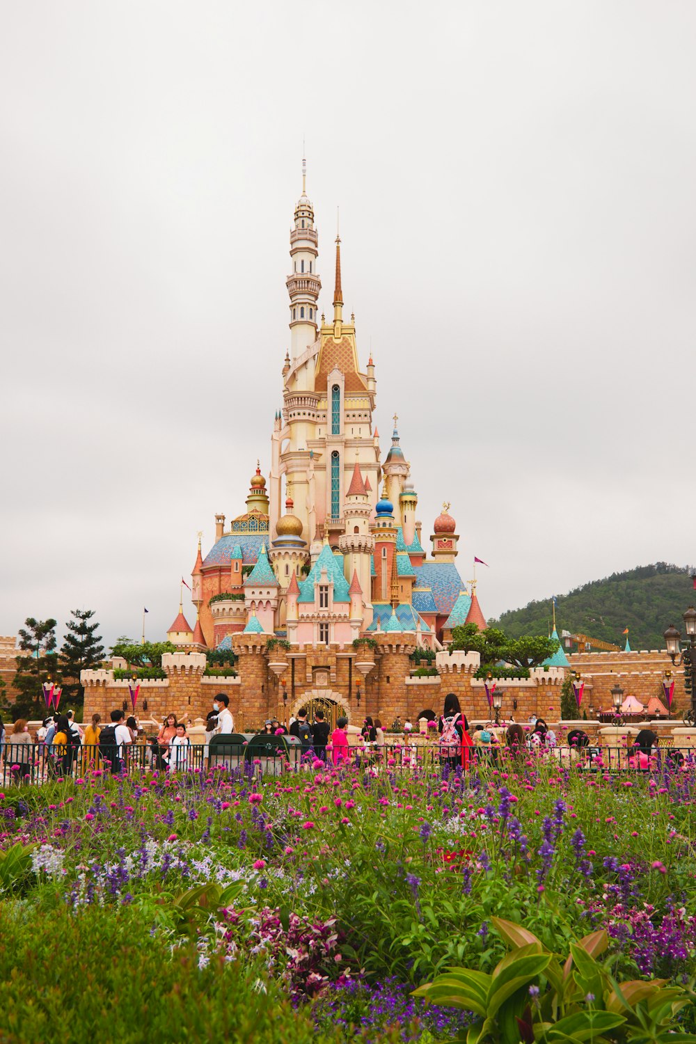 brown and green castle surrounded by green trees under white clouds during daytime