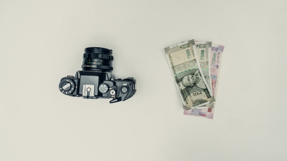 black dslr camera beside 20 banknote