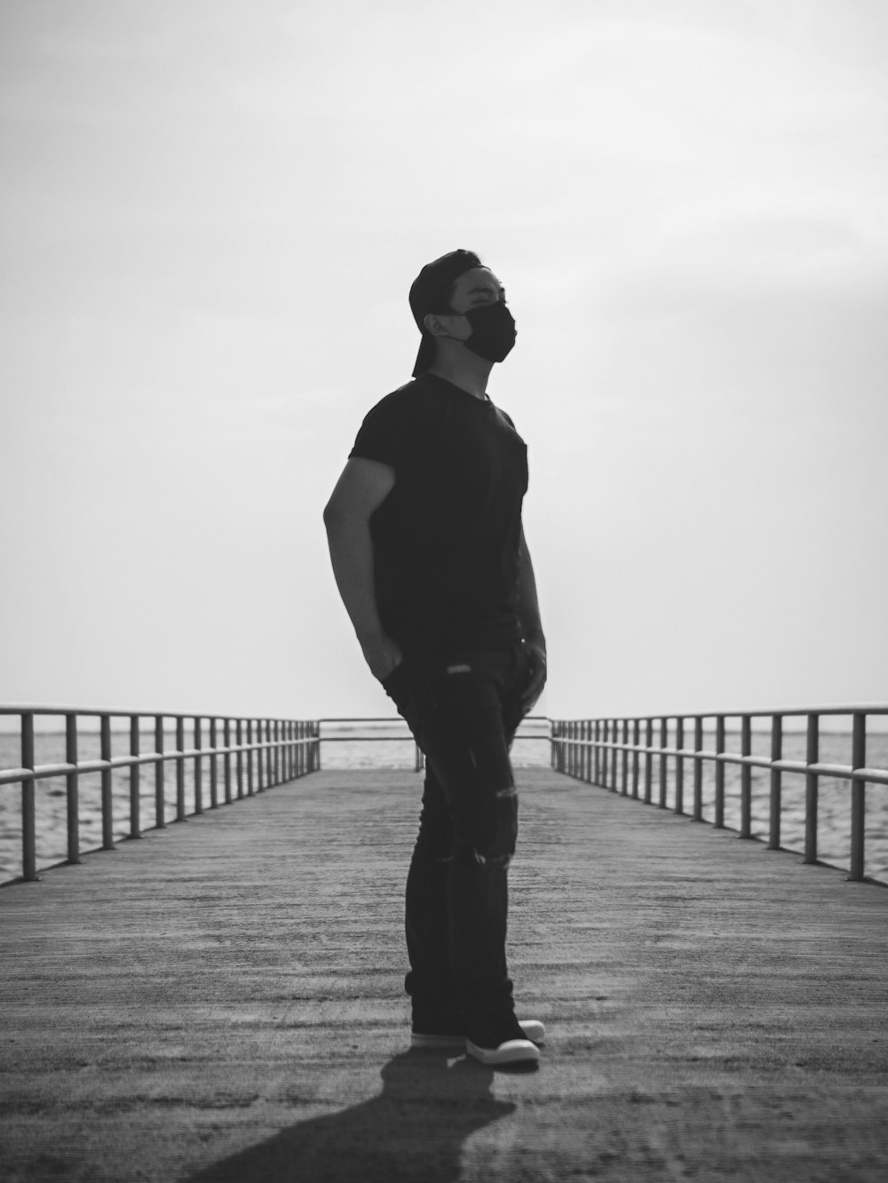 a man standing on a pier looking at the water