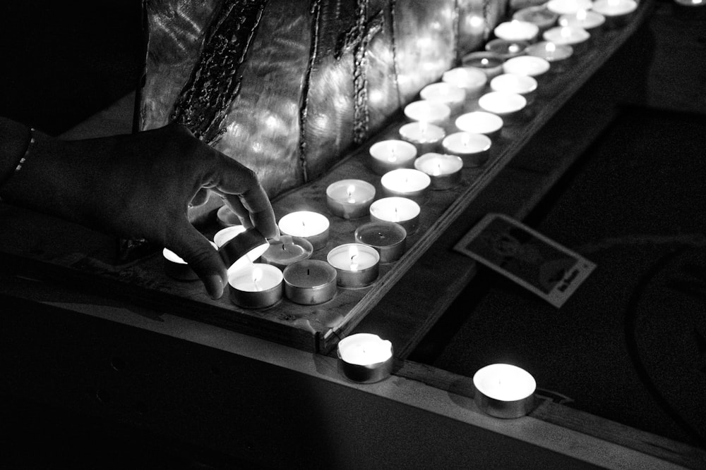 grayscale photo of candles on table