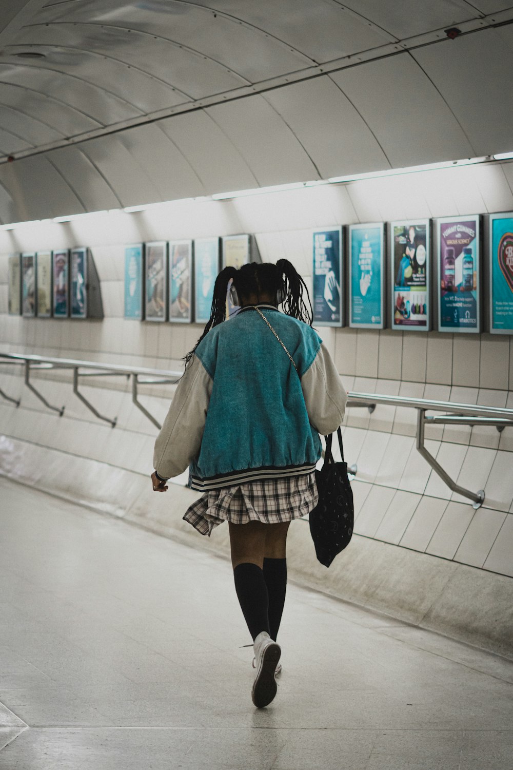 woman in gray shirt and black skirt walking on hallway