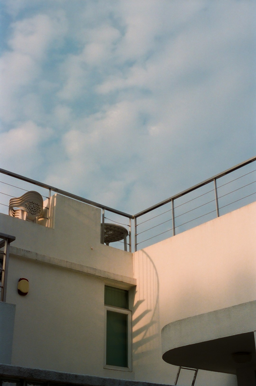 white concrete building under white clouds during daytime