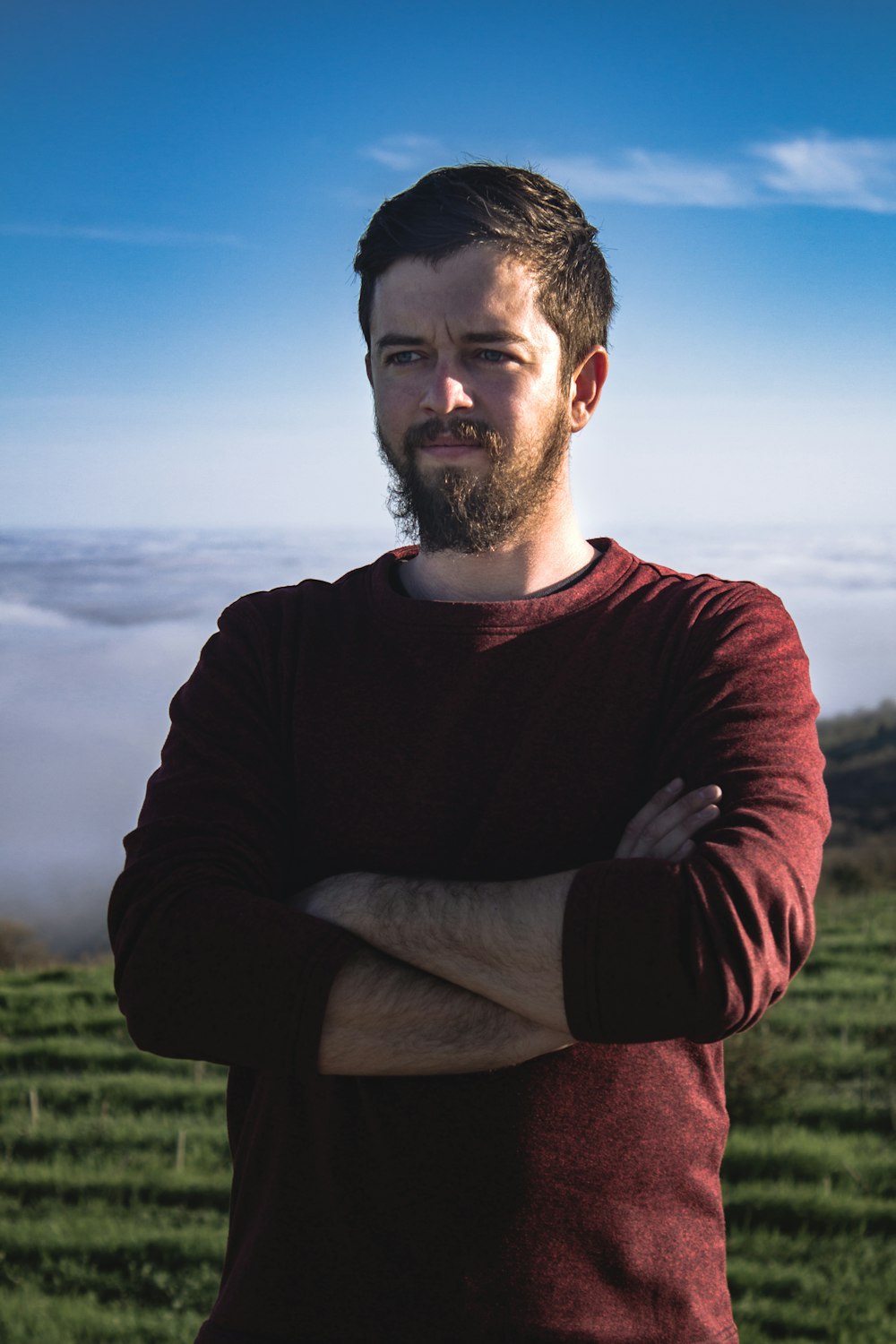 man in black long sleeve shirt sitting on green grass field during daytime