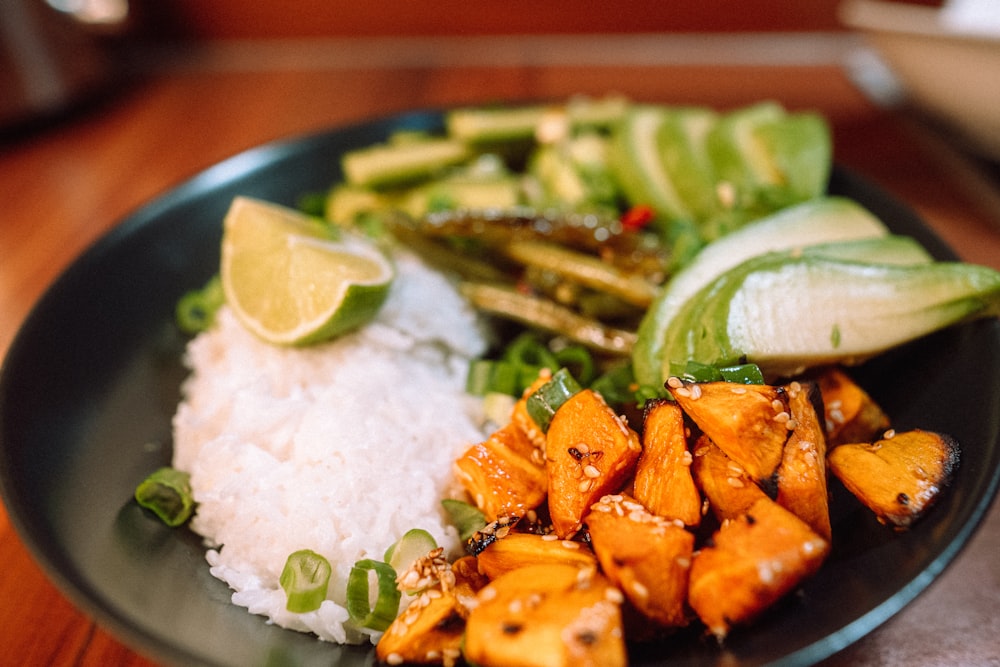 sliced carrots and green vegetable on blue ceramic plate