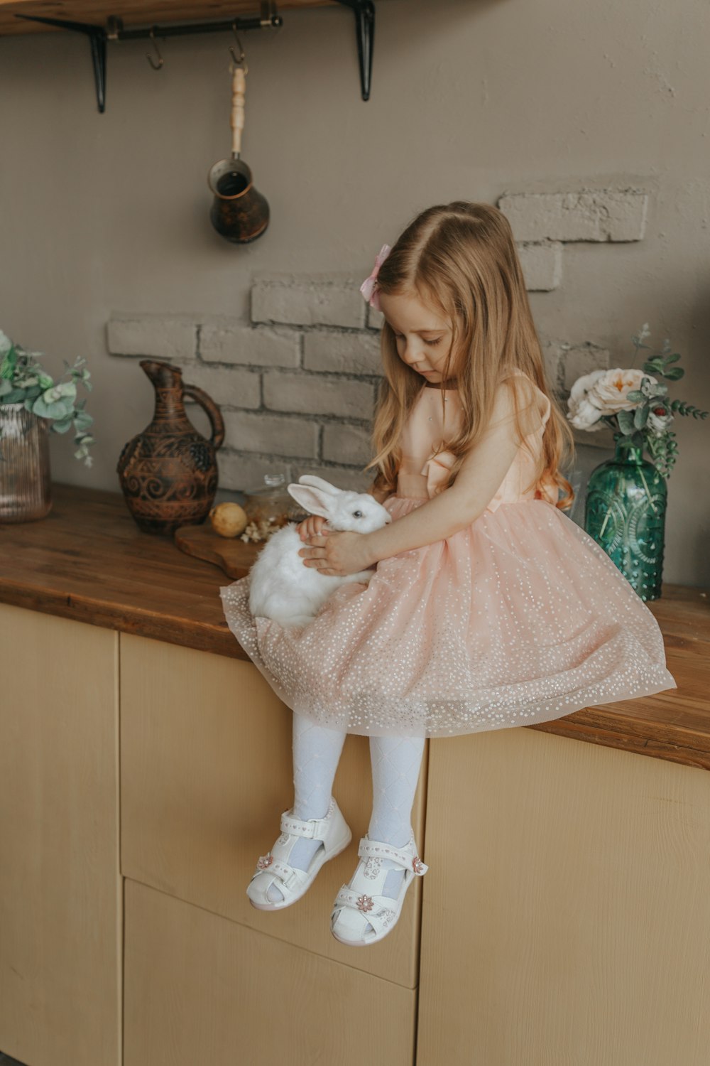 woman in pink dress holding white rabbit plush toy