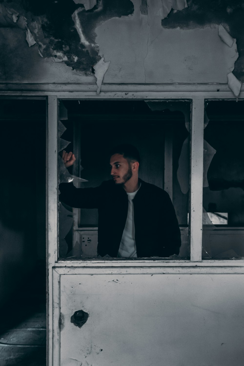 a man in a suit and tie standing in a window