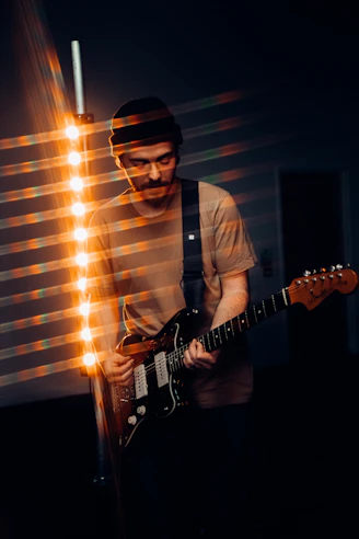 man in white dress shirt playing electric guitar