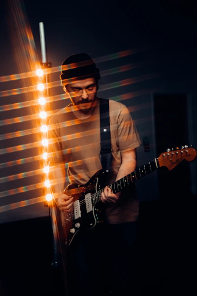 man in white dress shirt playing electric guitar