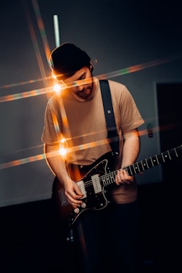 man in white crew neck t-shirt playing electric guitar