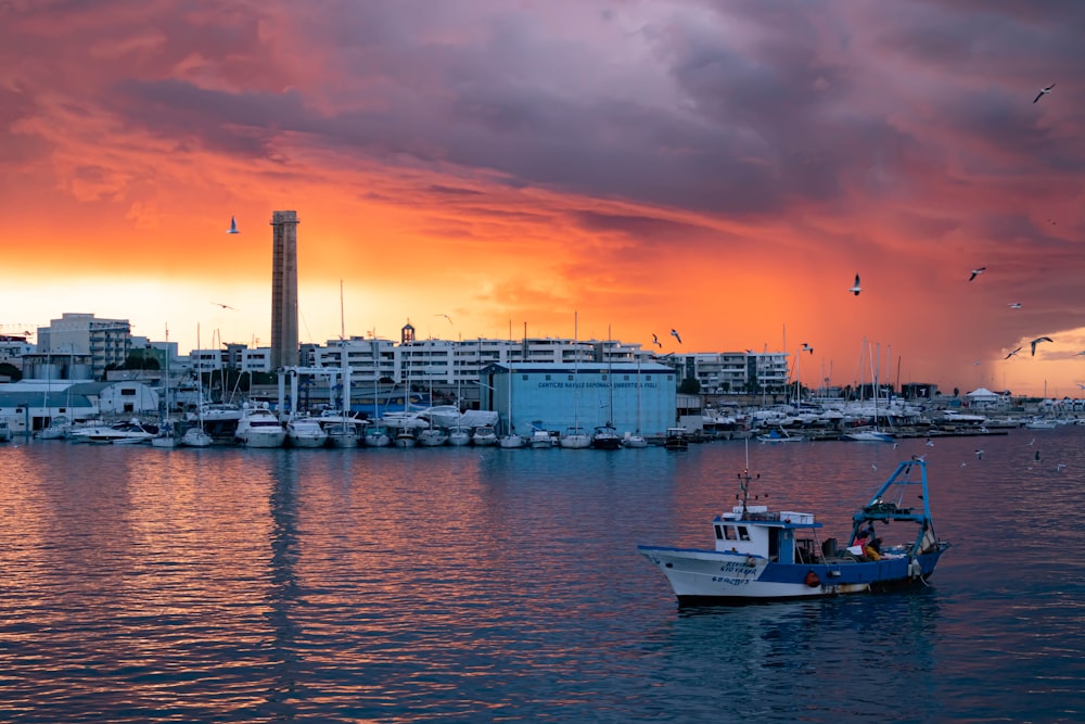 white boat on body of water during sunset