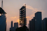 A sleek architectural blueprint overlaying a modern skyscraper under construction at sunset.