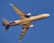 A commercial cargo airplane in flight against a clear blue sky. The aircraft is viewed from below and is painted in light colors with purple accents.