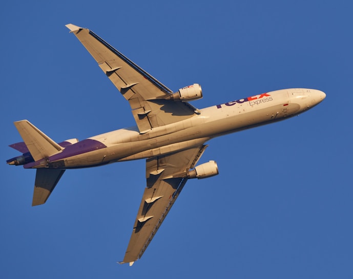 A cargo airplane soaring through a clear blue sky.