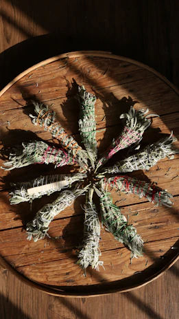 Close-up of fresh Ayurvedic herbs arranged on a rustic wooden table with soft natural light.