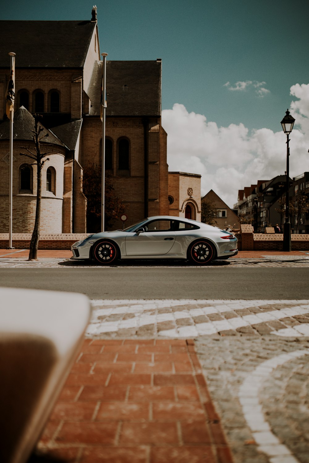 sedã prata estacionado na calçada durante o dia