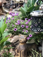 A sunlit garden corner with a small memorial stone surrounded by blooming flowers and a gentle cat silhouette.