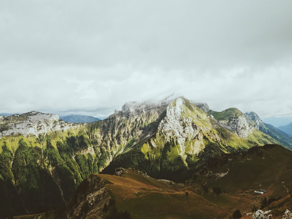 green and white mountain under white clouds during daytime