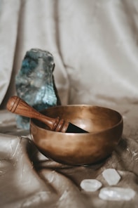 brown wooden spoon on brown round singing bowl