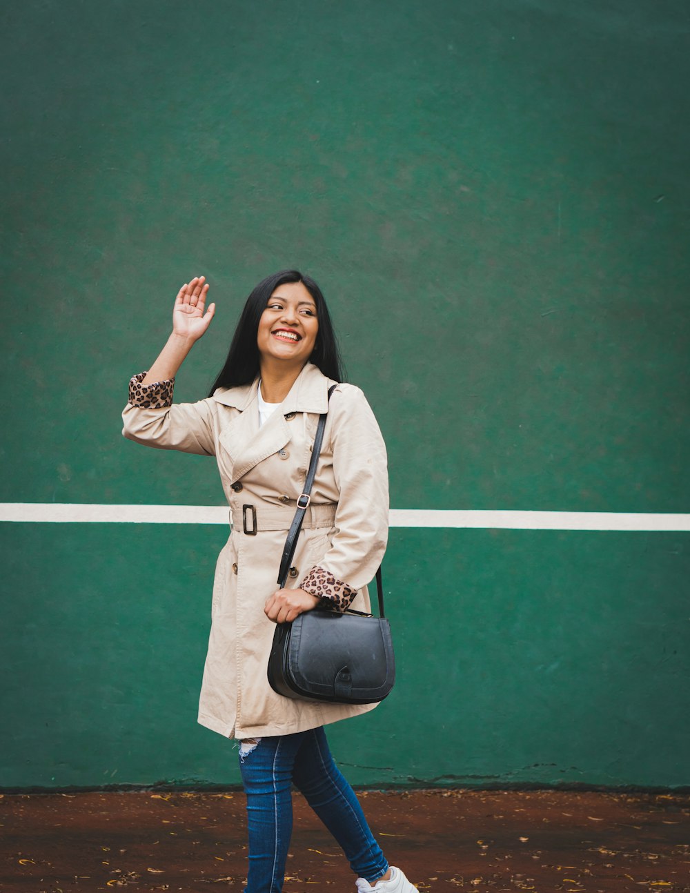 woman in beige blazer standing and smiling