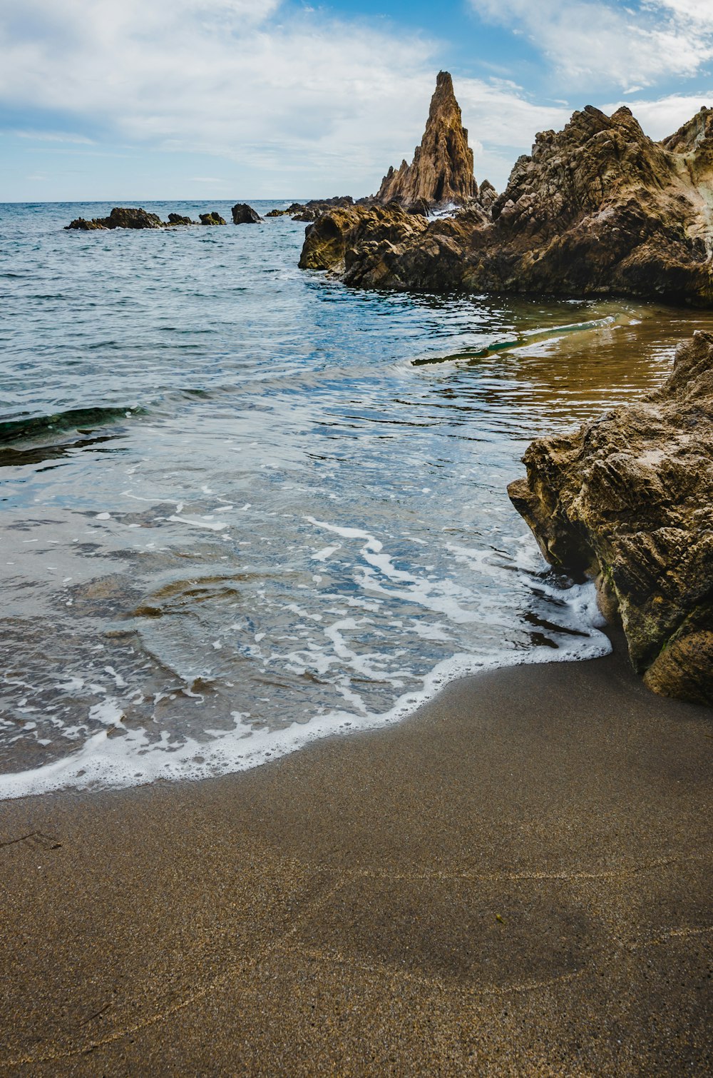 brown rock formation on sea shore during daytime