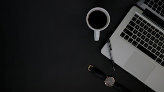 A sleek, dark-themed workspace with a laptop, notebook, and coffee cup, reflecting a professional learning environment.
