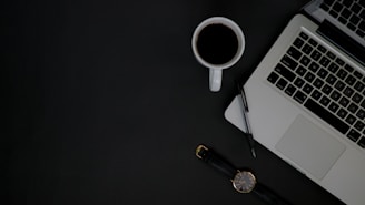 A professional office desk with a laptop and notepad.