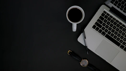 A sleek office workspace with a laptop, notebook, and coffee cup, symbolizing professional communication.