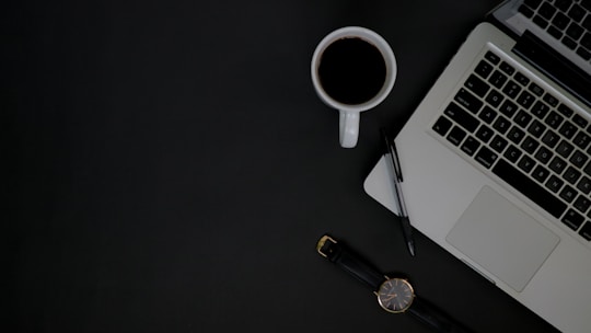 A professional workspace with a laptop, notepad, and coffee cup, symbolizing creativity.
