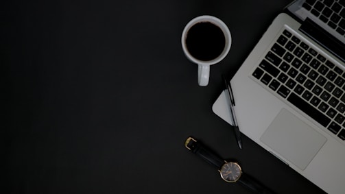 A professional office desk with a laptop and notepad.