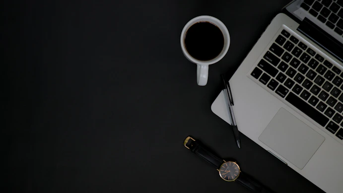 A sophisticated workspace with a laptop, coffee cup, and elegant notes, suggesting professional concierge service.