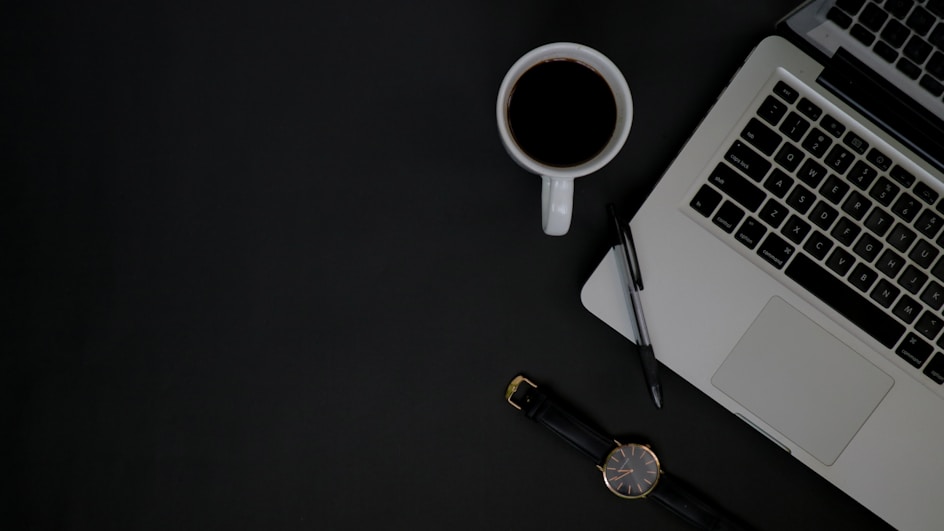 A focused freelancer working on a laptop with notes and a coffee, symbolizing organized digital entrepreneurship.