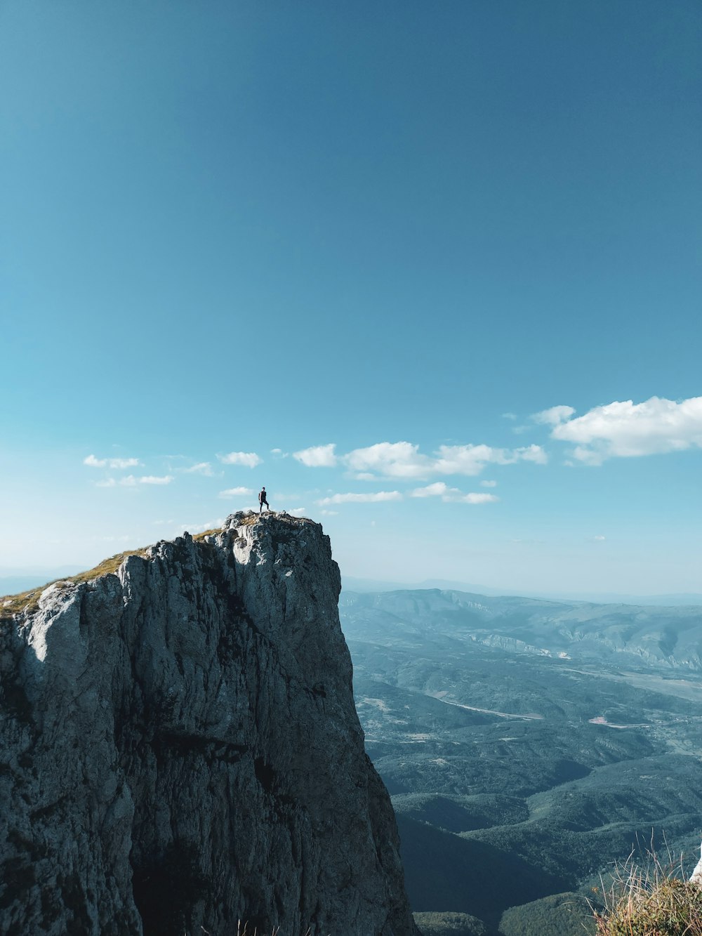 Persona in piedi sulla cima della montagna durante il giorno