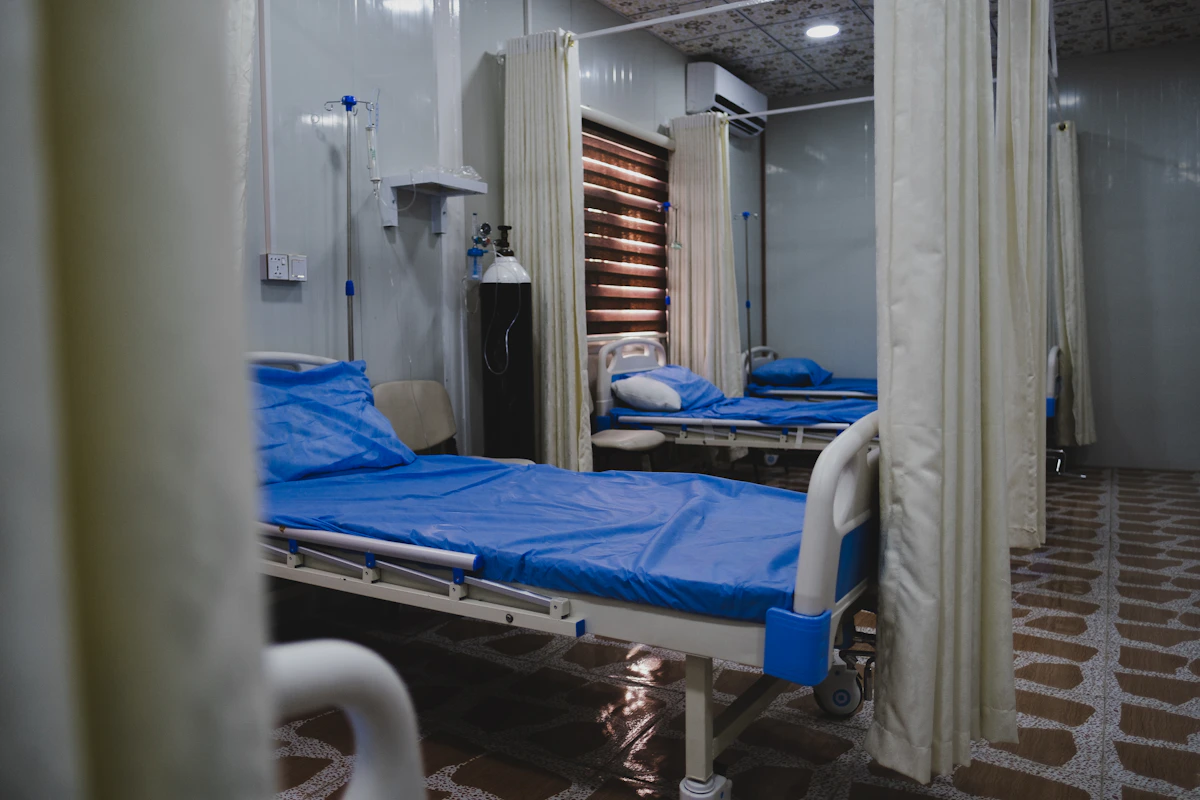 A clean hospital bed made with fresh blue and white linens