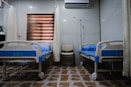 white split type air conditioner over white and blue hospital bed